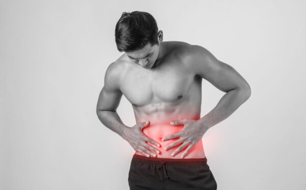 Young handsome Muscular man has abdominal pain isolated on white background.