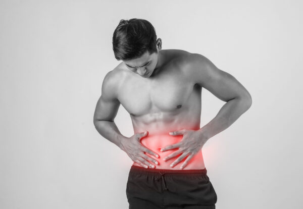 Young handsome Muscular man has abdominal pain isolated on white background.